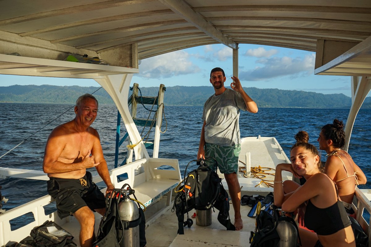 Briefing de buceo con buceadores felices en el barco en Port Barton